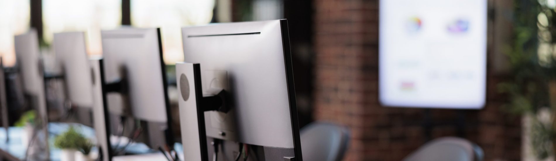 Nobody in office with multiple monitors at customer service desk, call center helpline support to give telecommunication assistance. Empty helpdesk with client telephony reception.